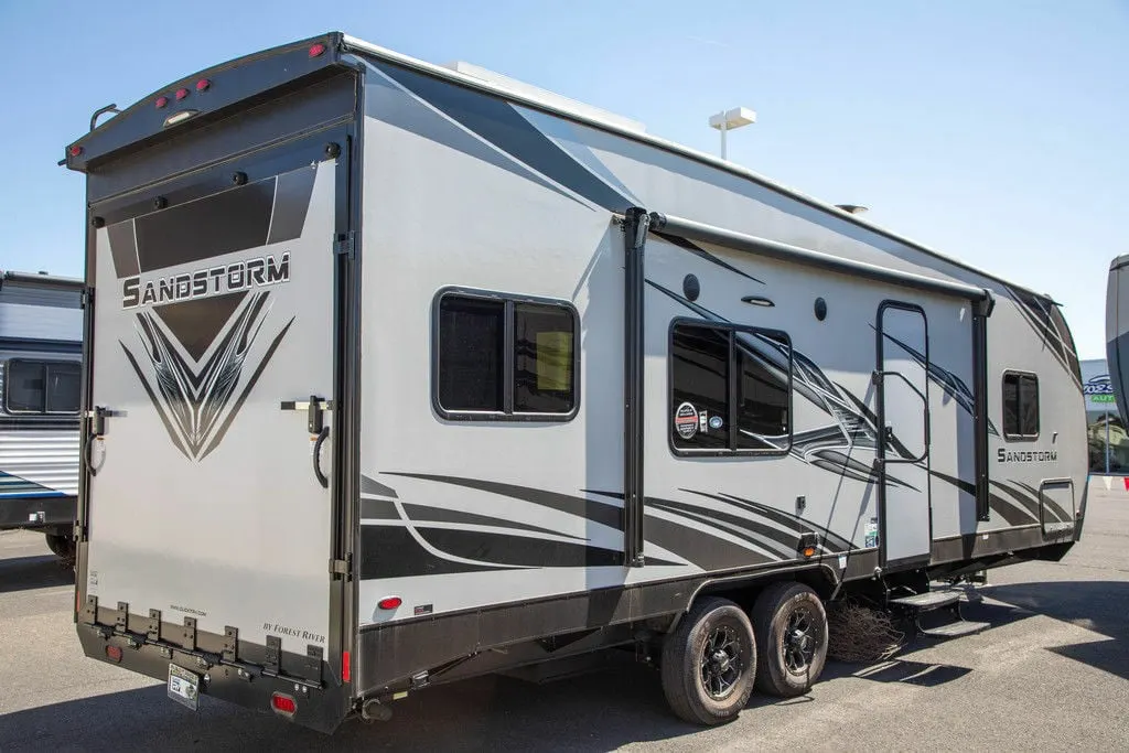 Side view of the New 2022 Forest River Travel Trailer Sandstorm SLC Series 242GSLC Toy Hauler RV.