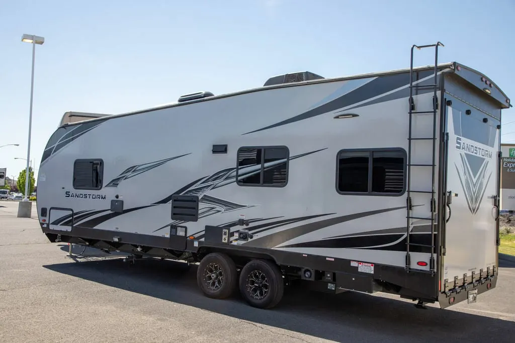 Side view of the New 2022 Forest River Travel Trailer Sandstorm SLC Series 242GSLC Toy Hauler RV.