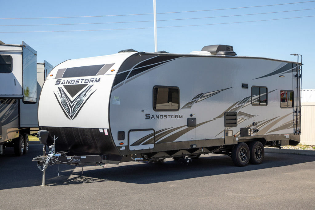 Side view of the New 2022 Forest River Travel Trailer Sandstorm SLC Series 242GSLC Toy Hauler RV.