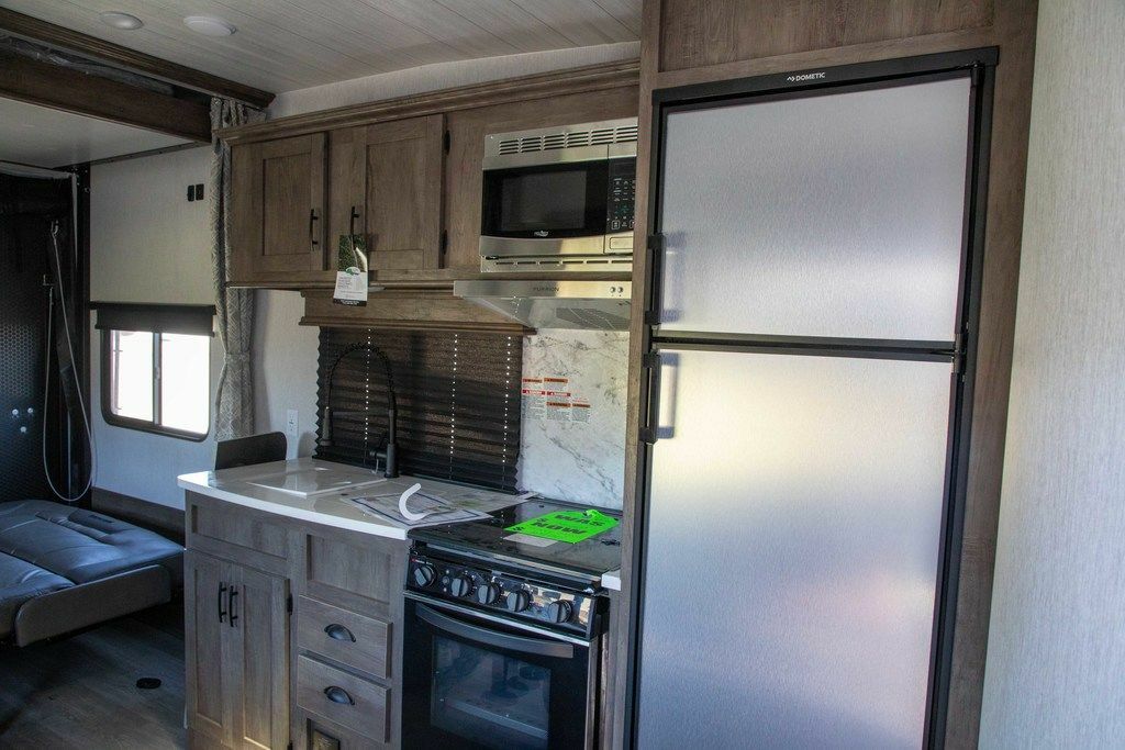 Kitchen with a gas burner, fridge, oven, sink and cabinets.