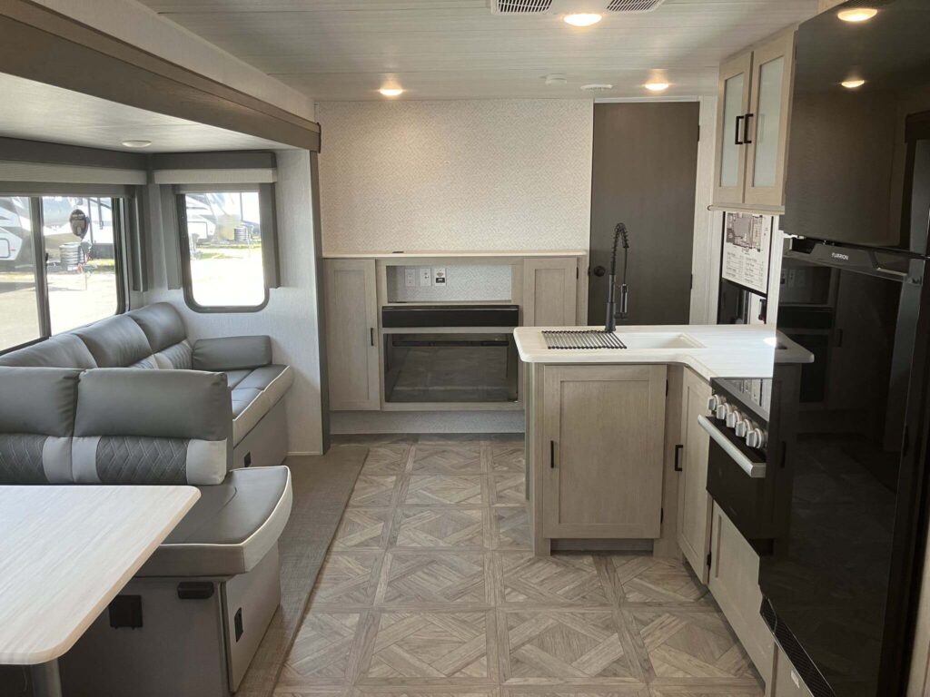 Interior view of the RV with a dinette, living space and a kitchen.