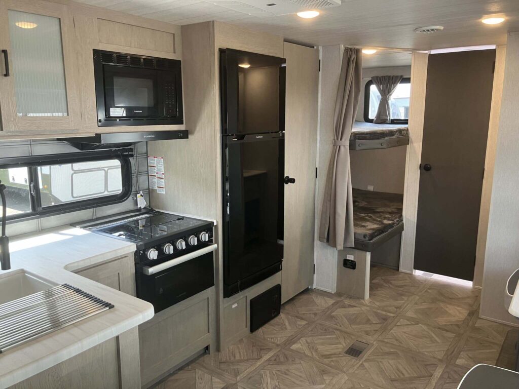 Kitchen with a gas range, fridge, oven, sink and cabinets.