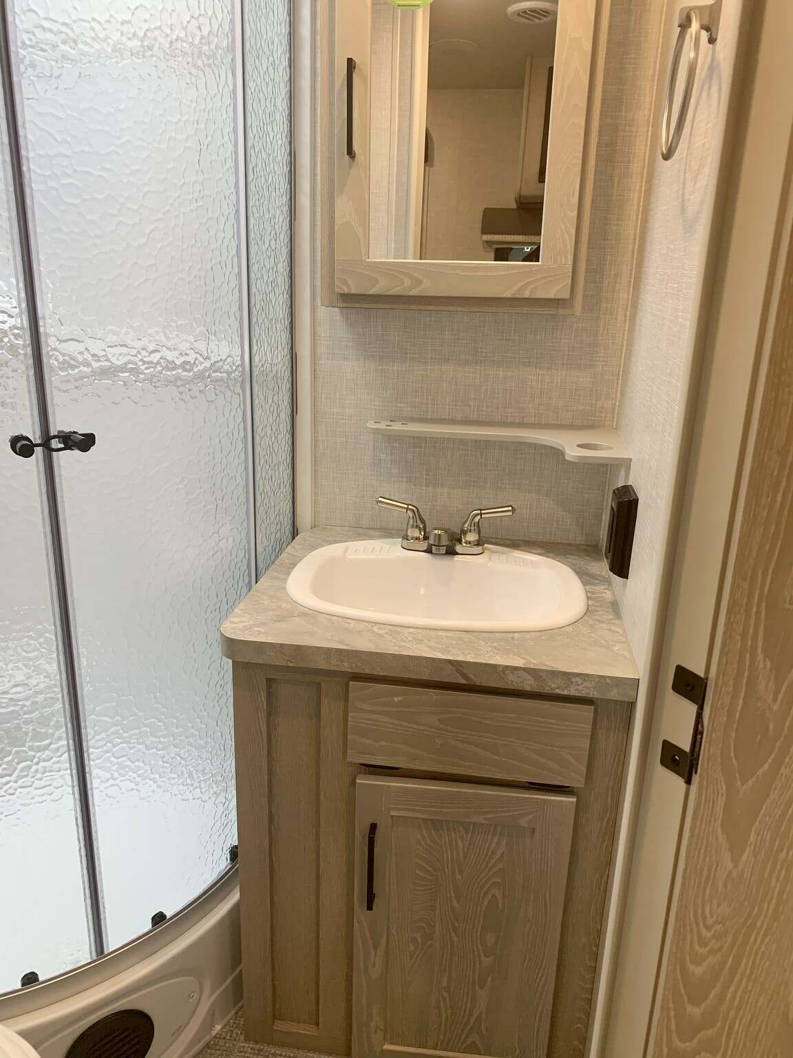 Bathroom with a sink, medicine cabinet and a walk-in shower.