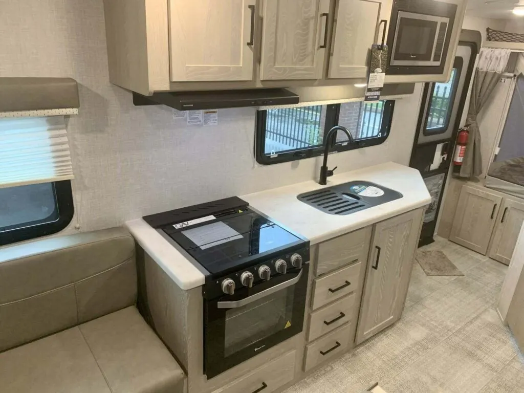 Kitchen with a gas burner, oven, sink and cabinets.