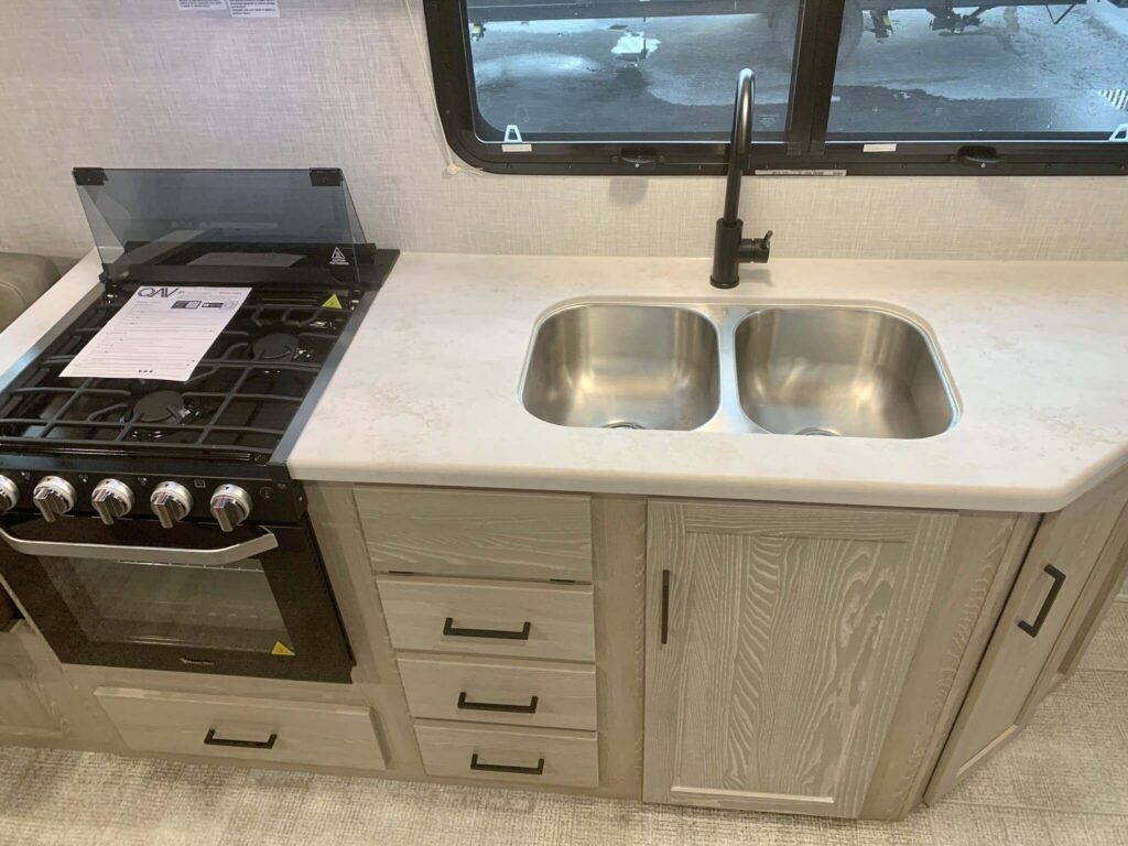 Kitchen with a gas burner, sink and cabinets.