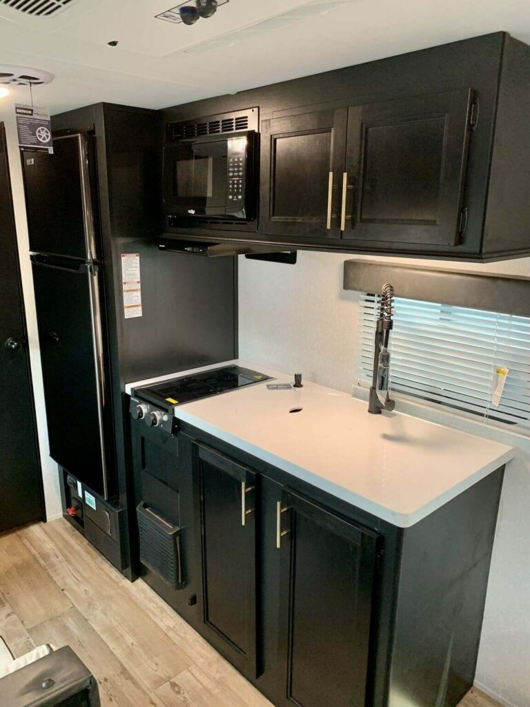 Kitchen with a gas burner, fridge, oven, sink and cabinets.