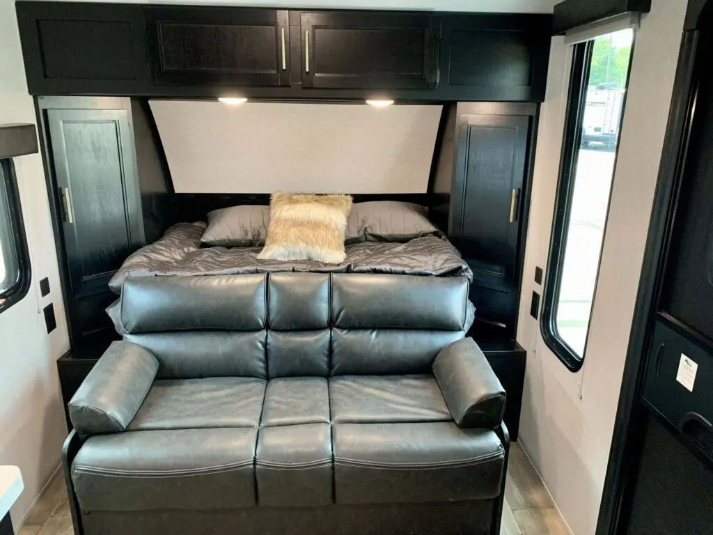 Bedroom flanked by the living space's leather seats.