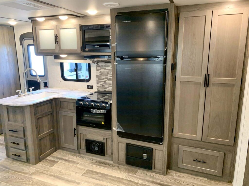 Kitchen with a gas burner, fridge, oven, sink and cabinets.