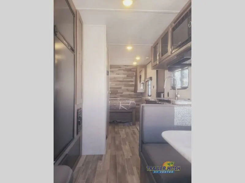 Interior view of the RV with a dinette, bedroom and a kitchen.