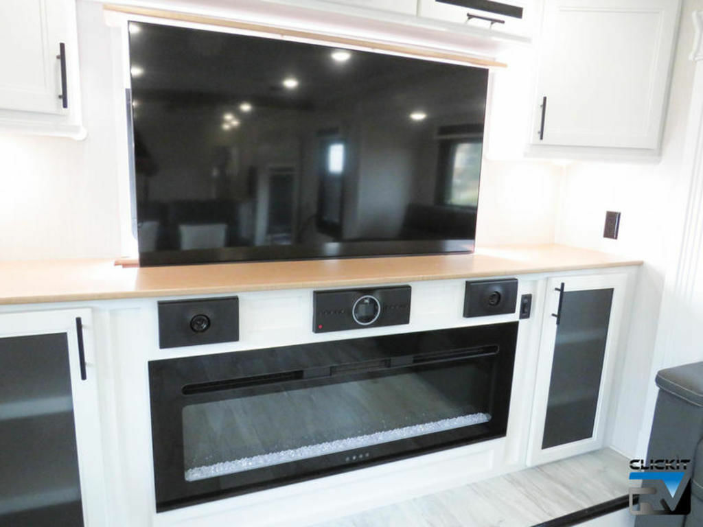 Entertainment center with a TV and a fireplace.