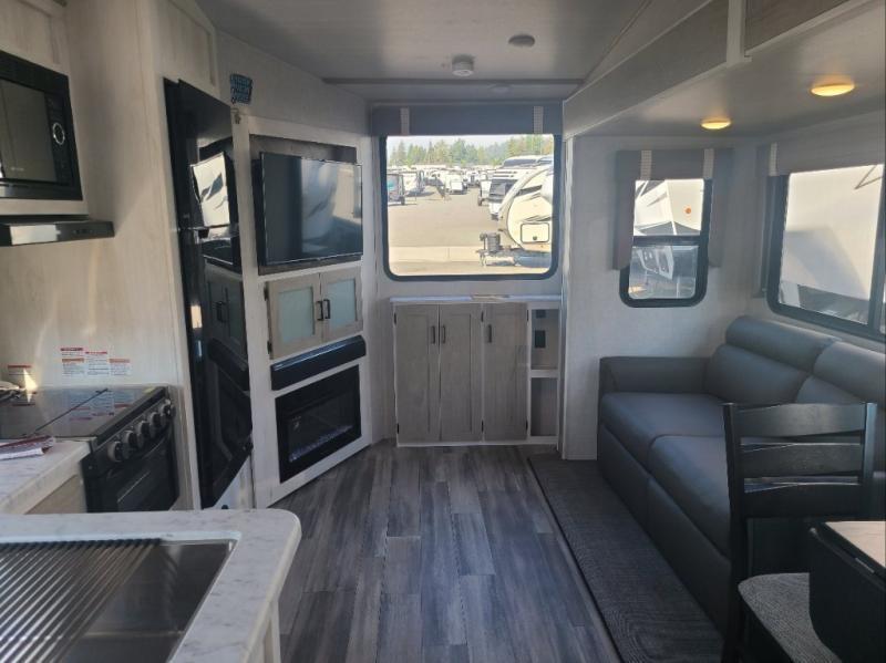 Interior view of the RV with a dinette, living space and a kitchen.