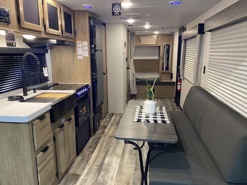 Interior view of the RV with a dinette, bedroom and a kitchen.