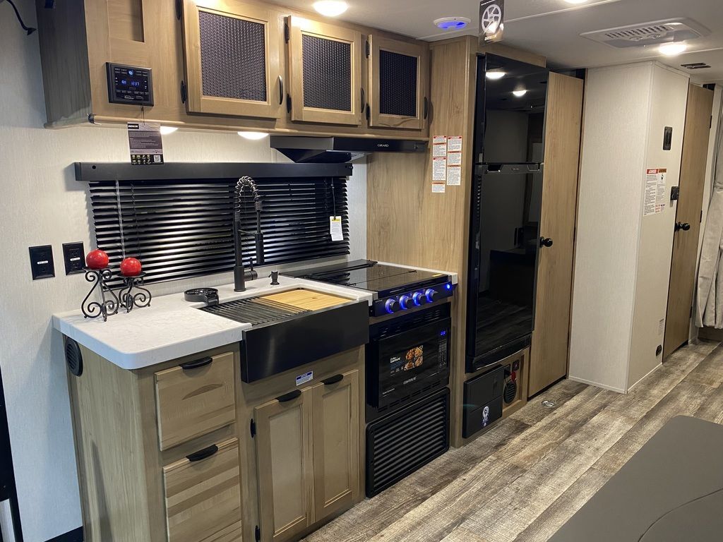 Kitchen with a gas range, fridge, sink and cabinets.