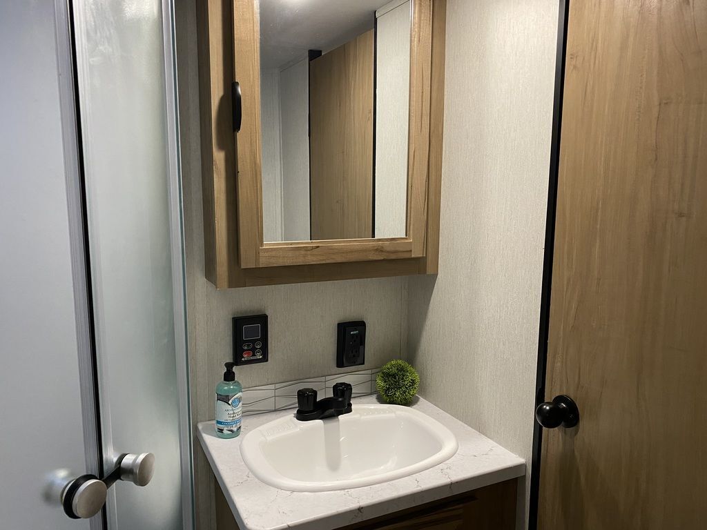 Bathroom with a sink, medicine cabinet and a walk-in shower.