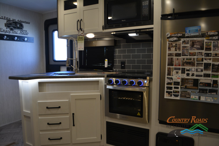 Kitchen with a gas range, fridge, oven, sink and cabinets.