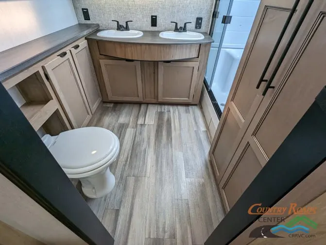 Bathroom with sinks, toilet and a walk-in shower.