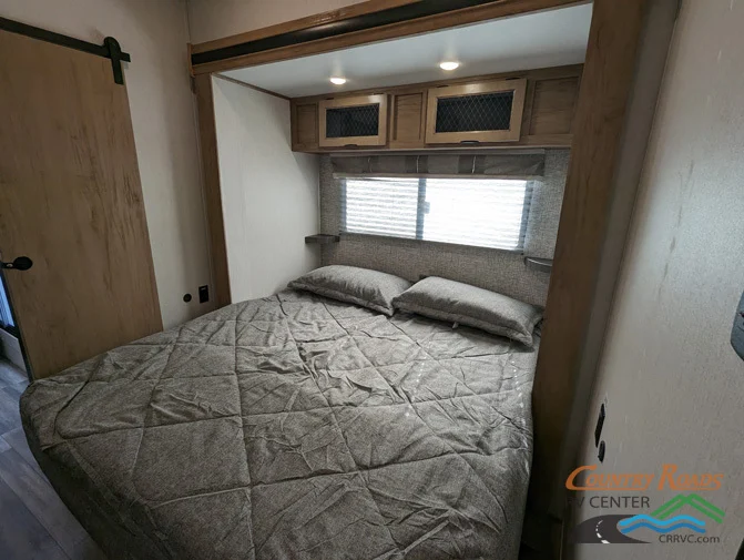 Bedroom with a king size bed and overhead cabinets.