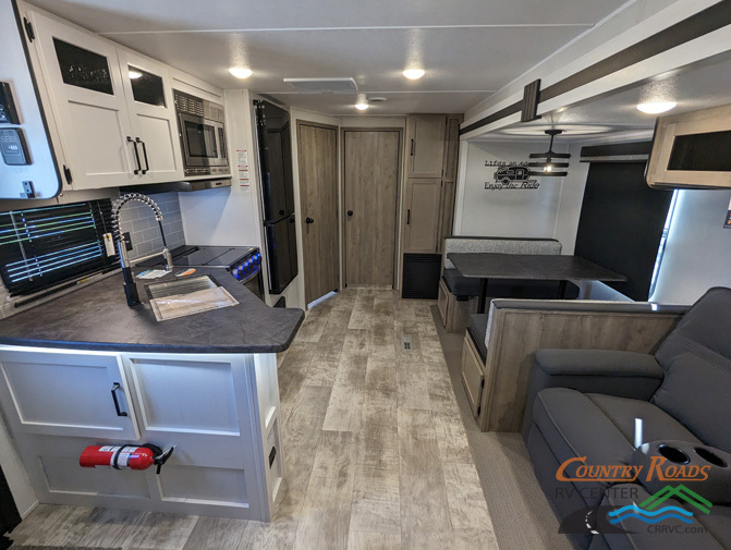 Interior view of the RV with a dinette, living space and a kitchen.