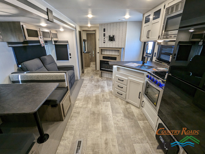 Interior view of the RV with a dinette, living space and a kitchen.