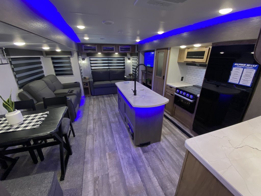 Interior view of the RV with a dinette, living space and a kitchen.