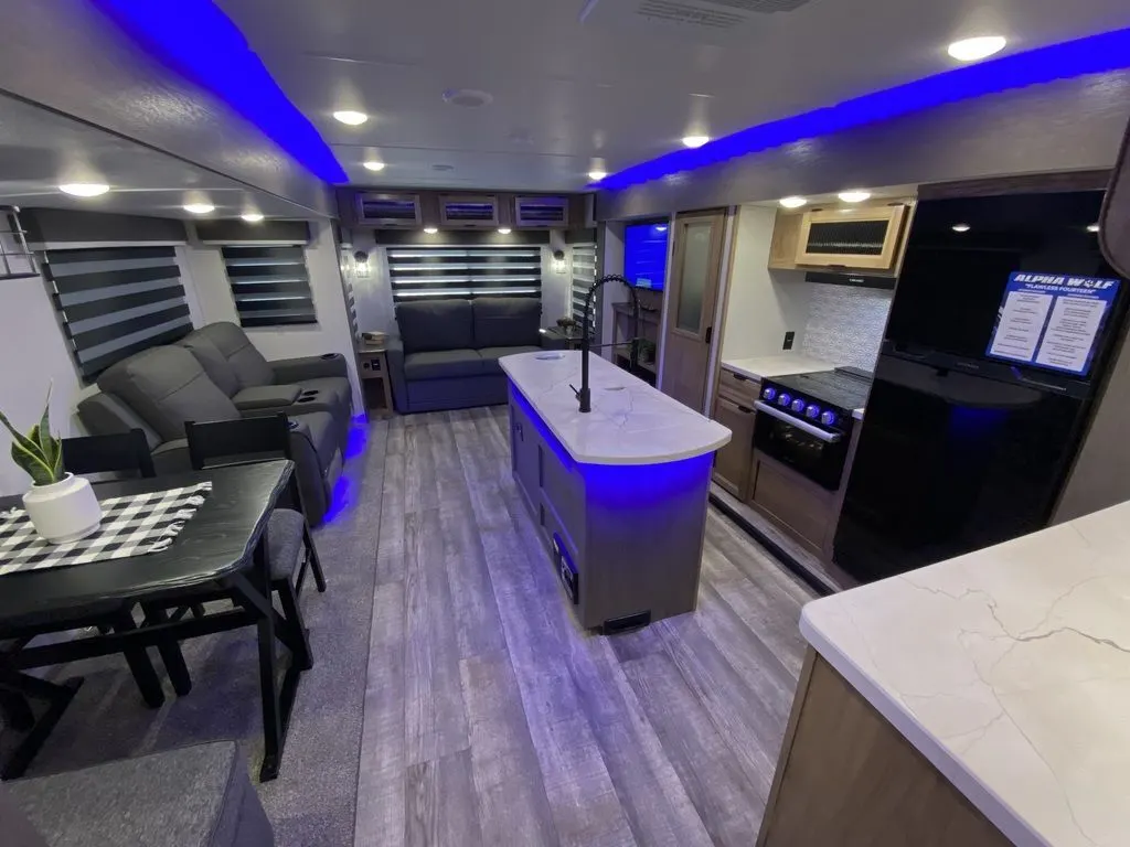 Interior view of the RV with a dinette, living space and a kitchen.