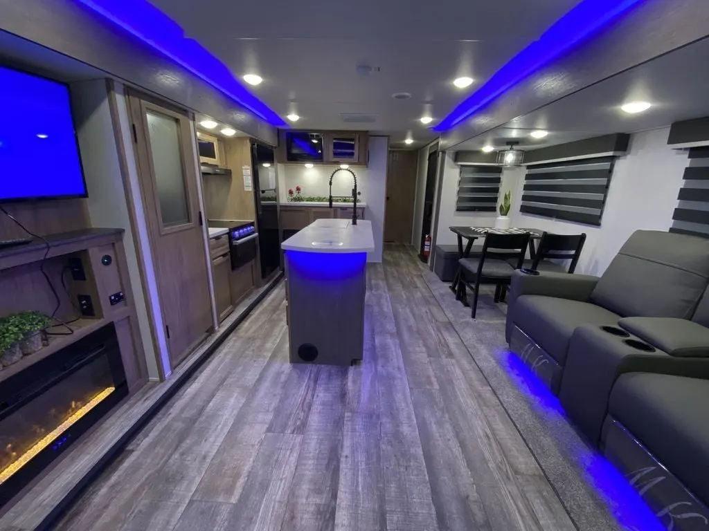 Interior view of the RV with a dinette, living space and a kitchen.