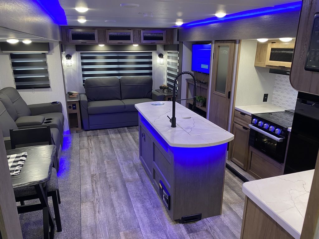 Interior view of the RV with a dinette, living space and a kitchen.