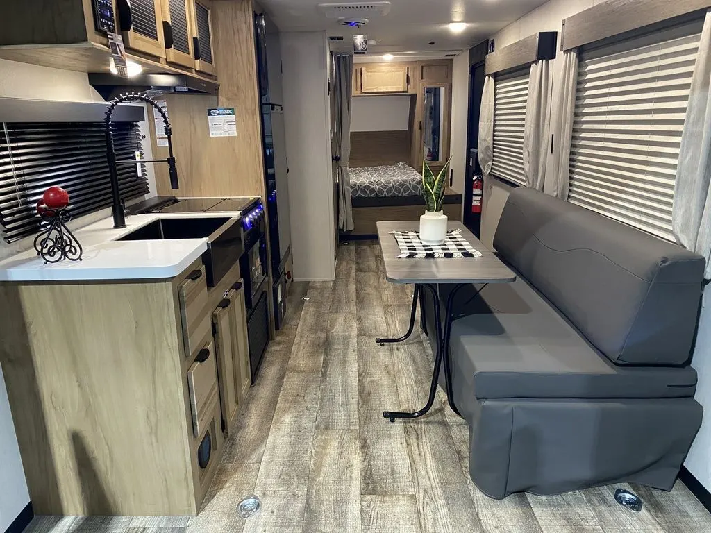 Interior view of the RV with a dinette, bedroom and a kitchen.