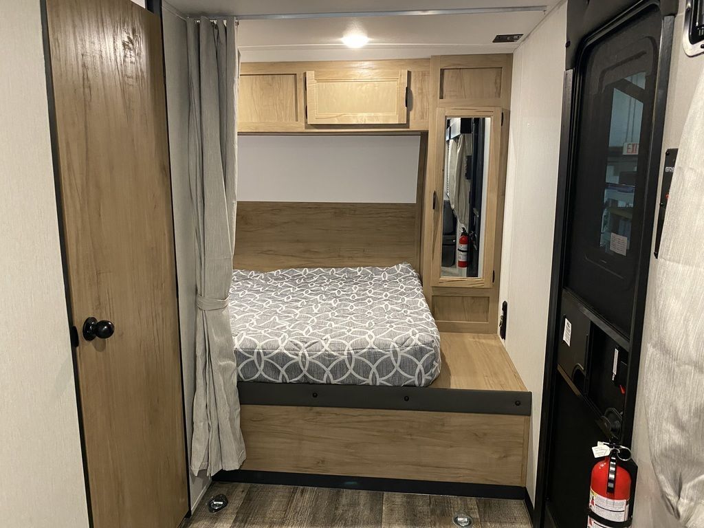 Bedroom with a queen size bed, overhead cabinets and shirt closets