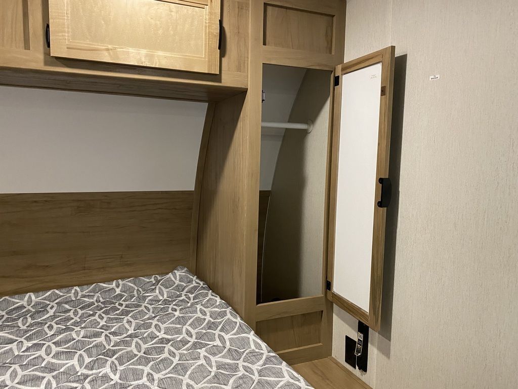 Bedroom with a queen size bed, overhead cabinets and shirt closets