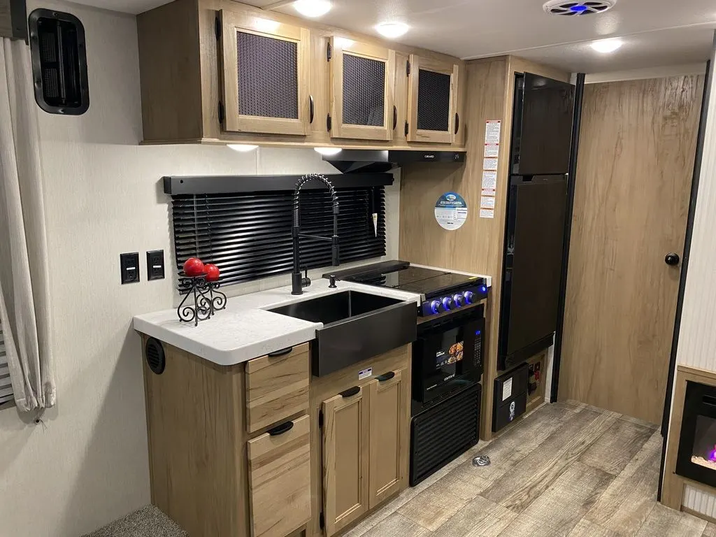 Kitchen with a gas range, fridge, sink and cabinets.