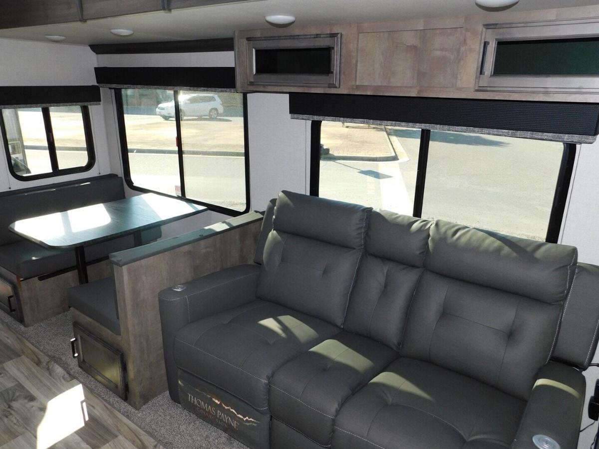 Living space with leather seats and overhead cabinets. 