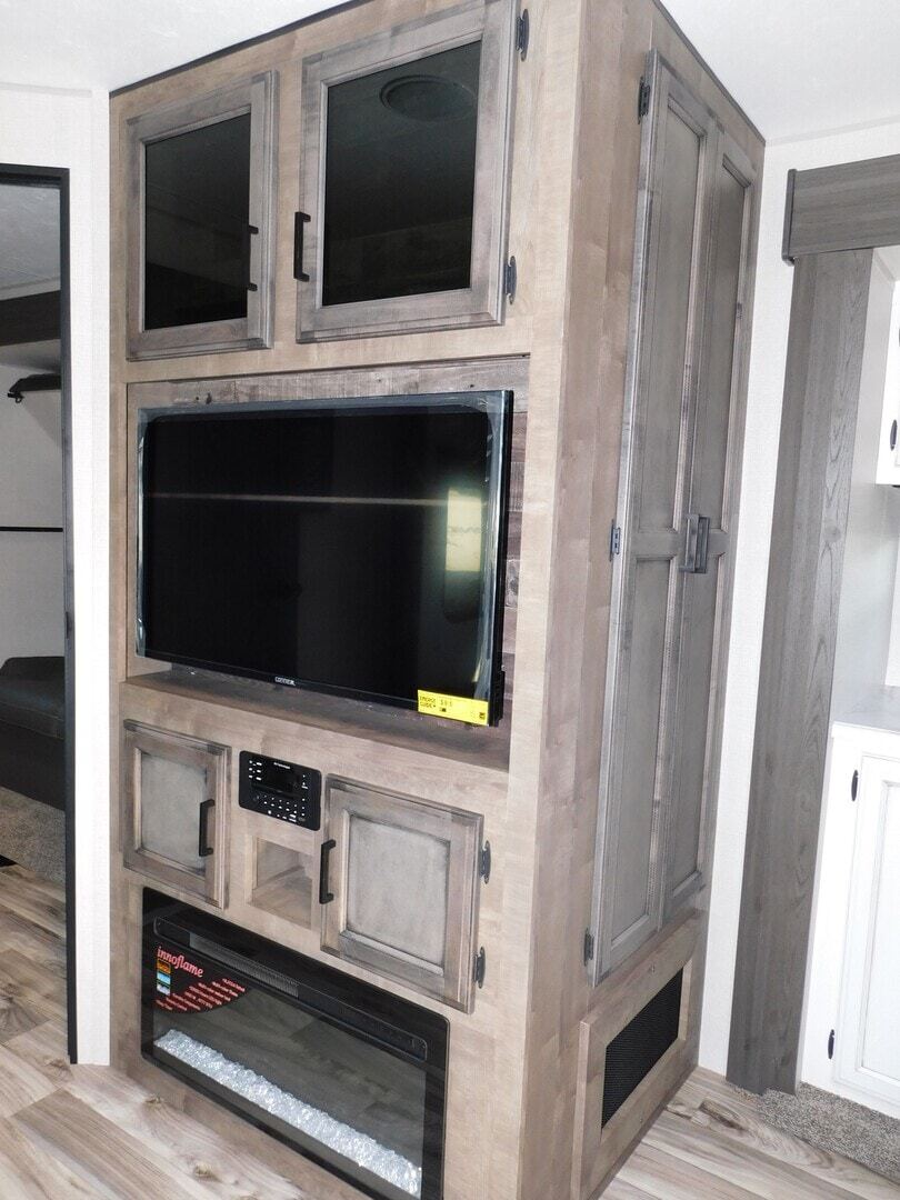 Entertainment center with a TV and a fireplace.