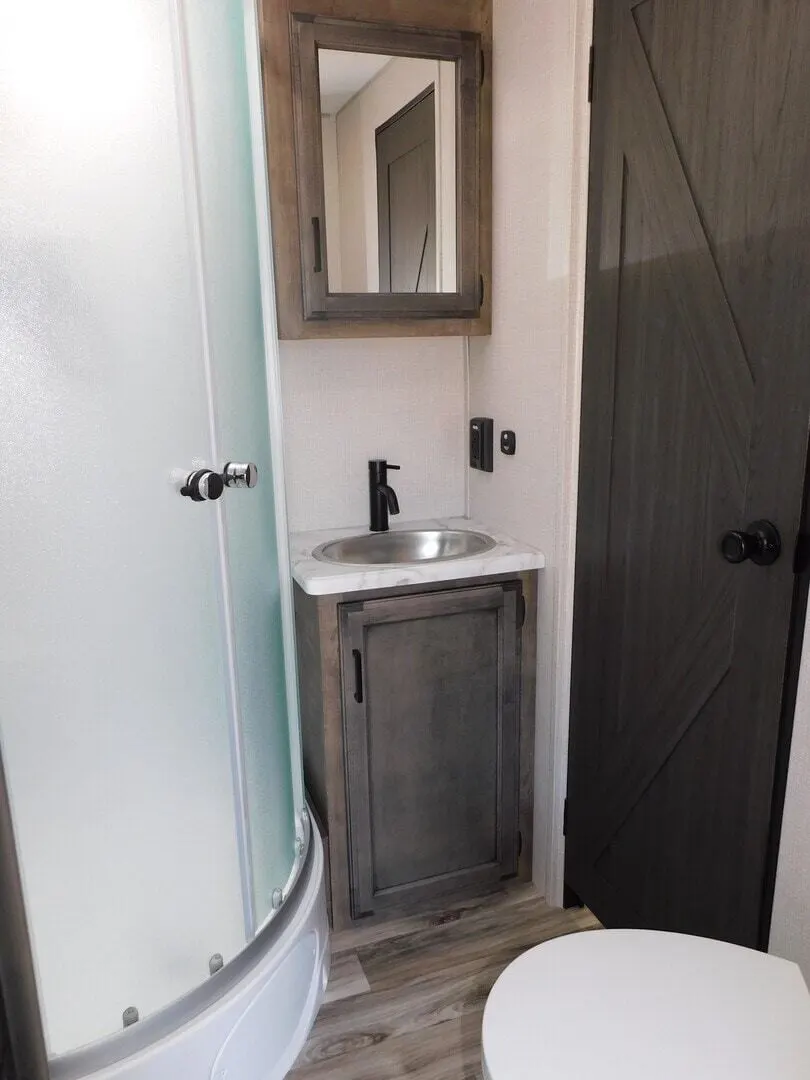 Bathroom with a sink, toilet and a walk-in shower.