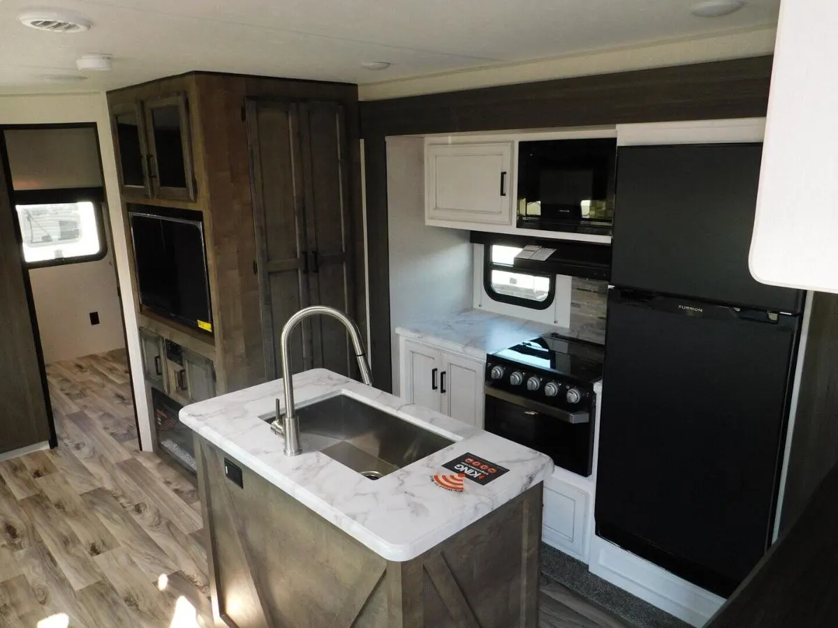 Kitchen with a gas range, fridge, oven, sink and cabinets.