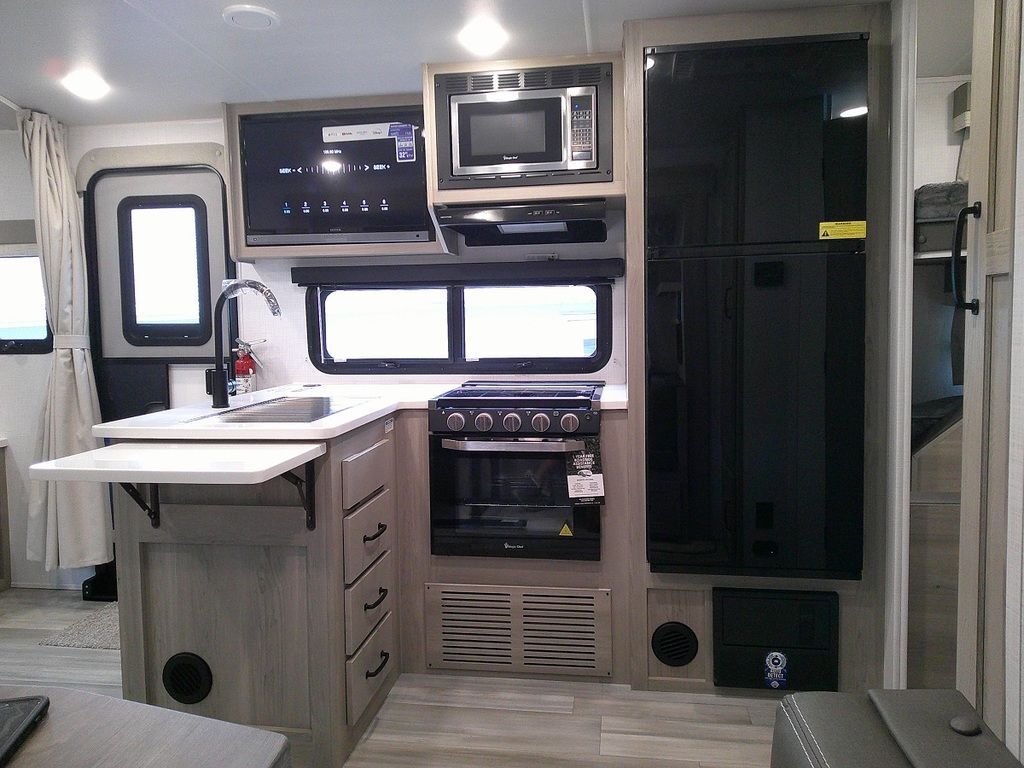 Kitchen with a gas range, fridge, oven, sink and cabinets.