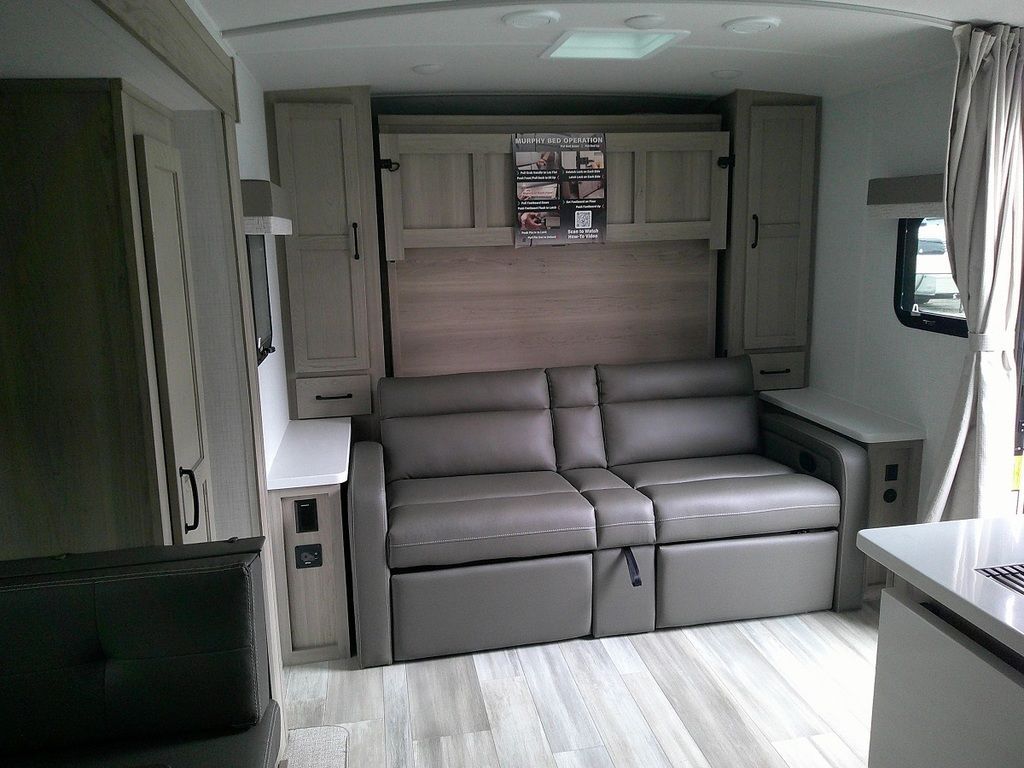 Living space with leather seats and overhead cabinets. 