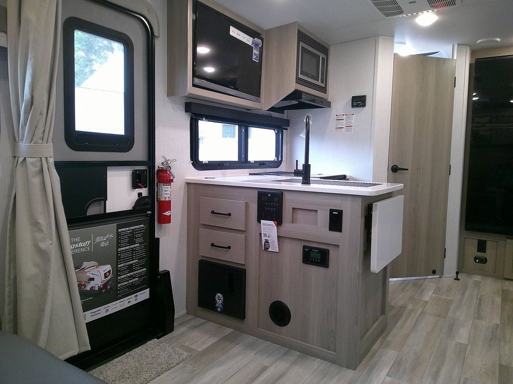 Kitchen with a gas range, fridge, oven, sink and cabinets.