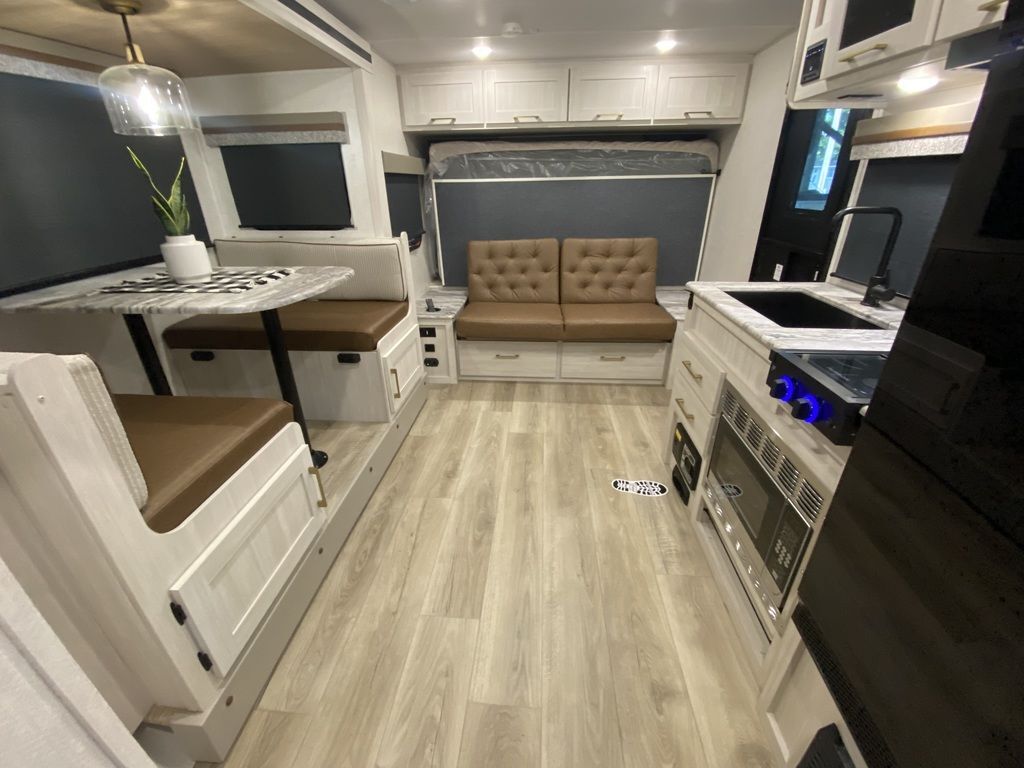 Interior view of the RV with a dinette, living space and a kitchen.