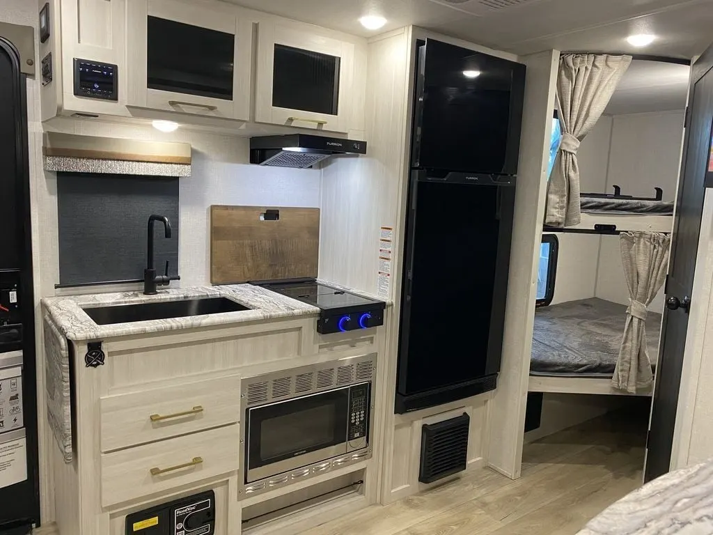 Kitchen with a gas range, fridge, oven, sink and cabinets.