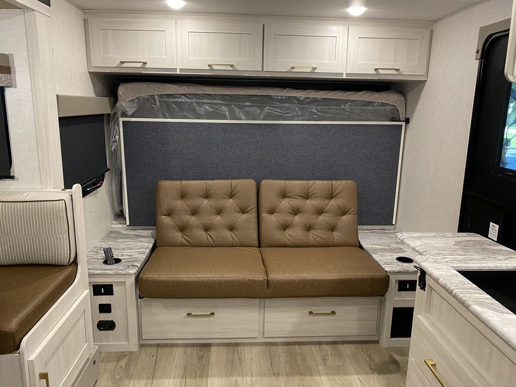 Living space with leather seats and overhead cabinets.  