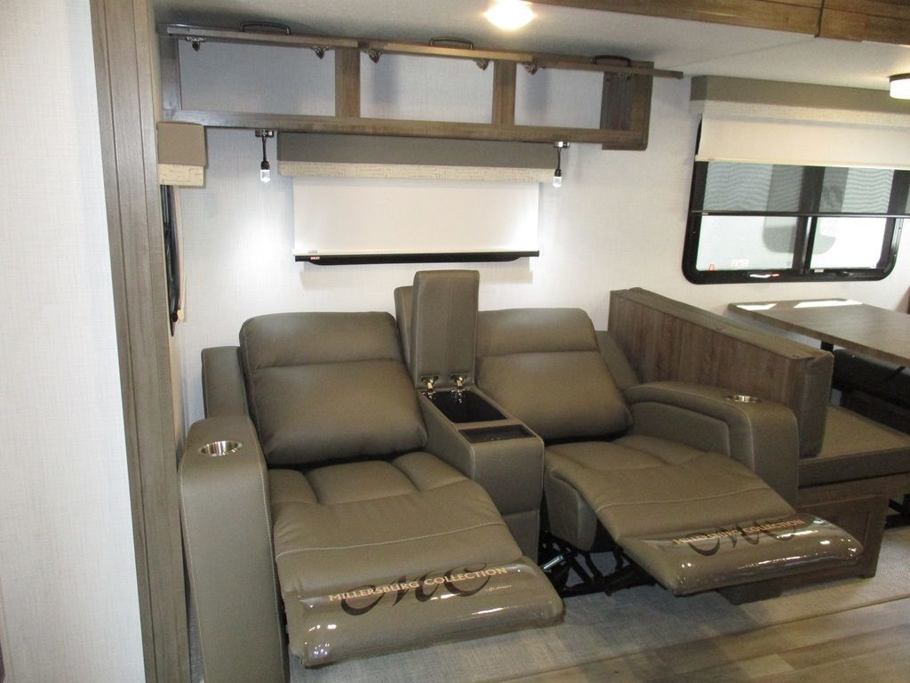 Living space with reclining chairs and overhead cabinets. 