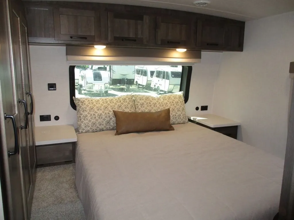 Bedroom with a queen size bed and overhead cabinets.