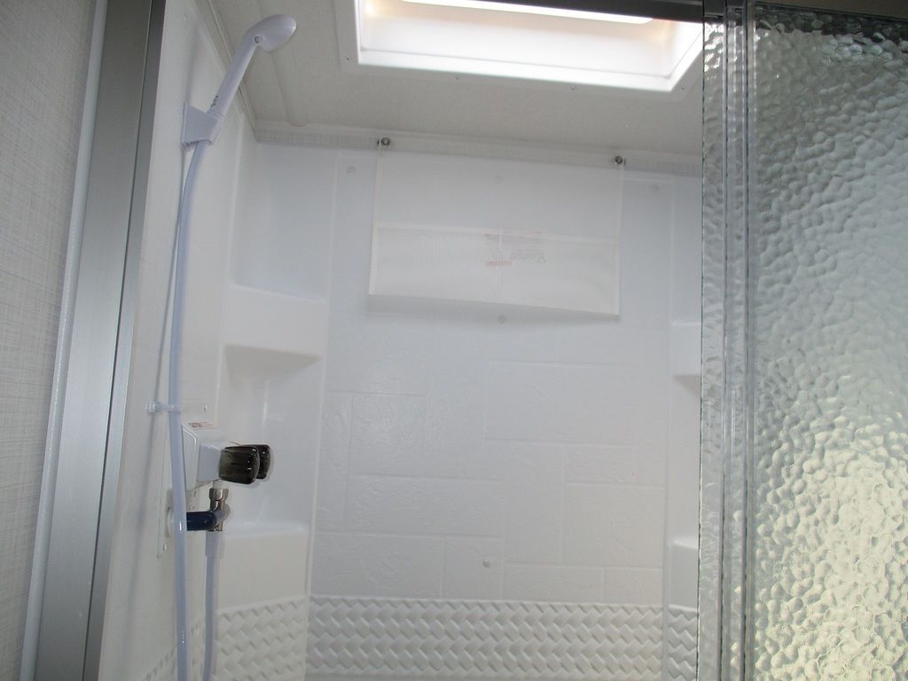 Bathroom with a walk-in shower and a skylight.