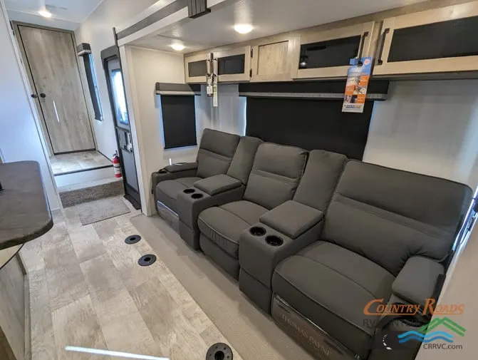 Living space with leather seats and overhead cabinets.  