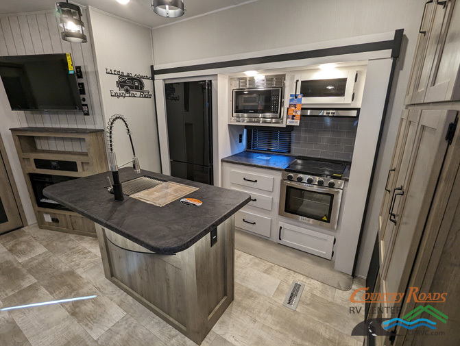 Kitchen with a gas range, fridge, oven, sink and cabinets.