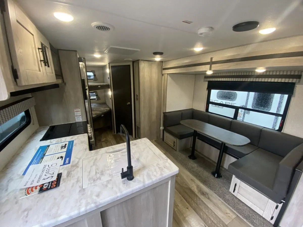 Interior view of the RV with a dinette, bedroom and a kitchen.