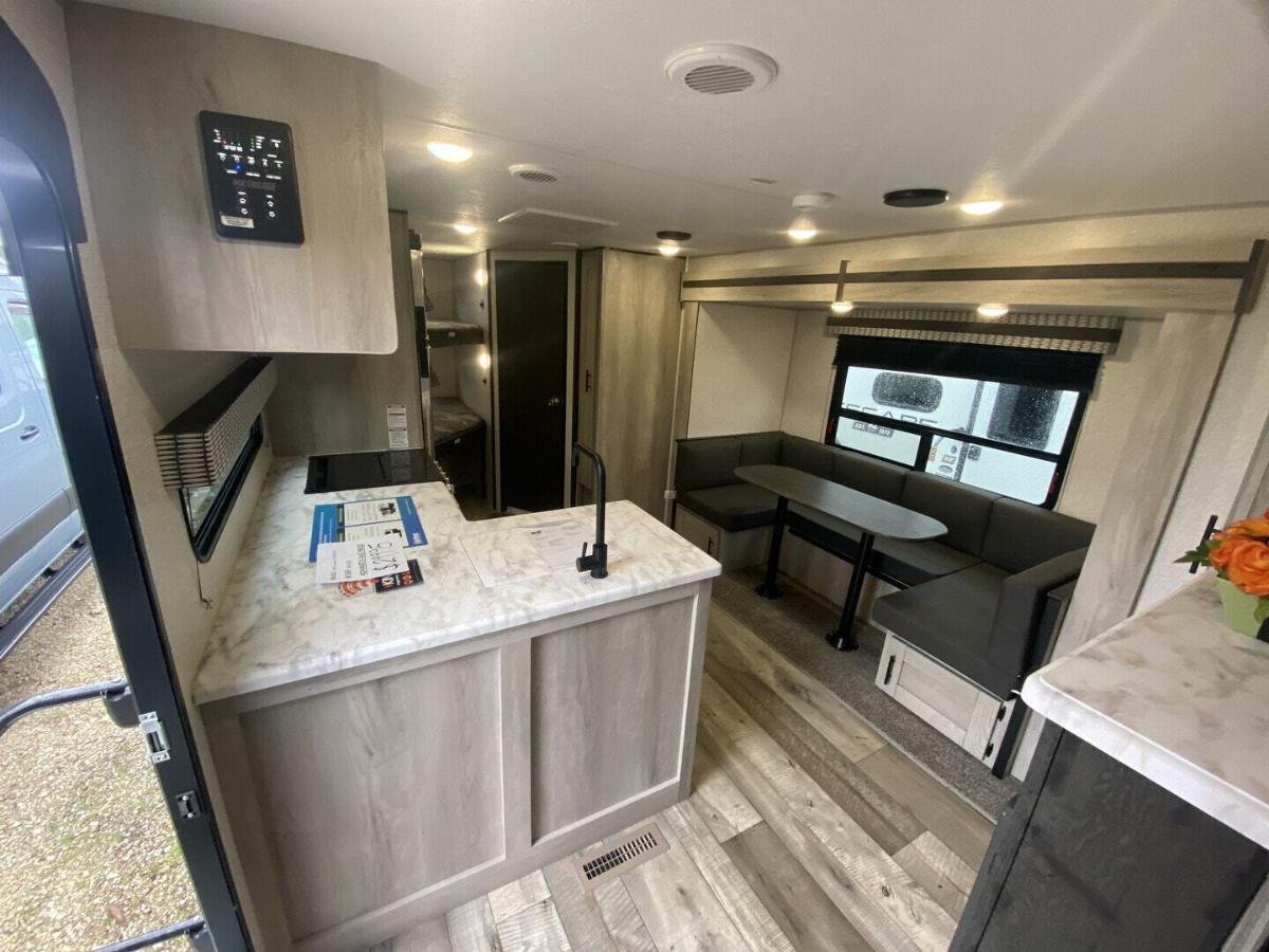 Interior view of the RV with a dinette, bedroom and a kitchen.