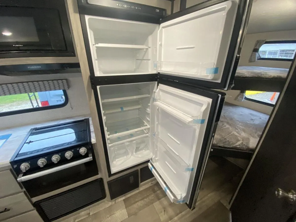 Kitchen with a gas range, fridge, and oven.