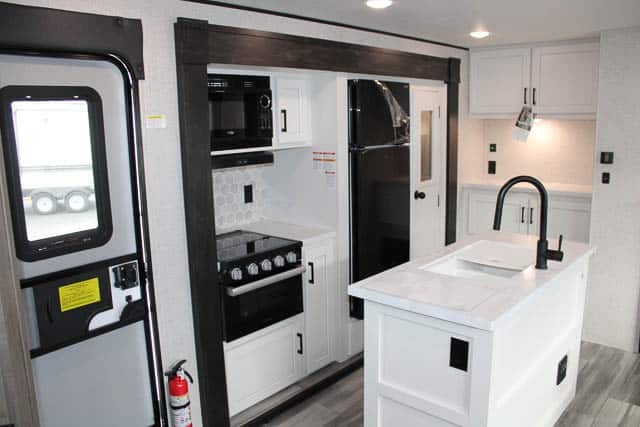 Kitchen with a gas range, fridge, oven, sink and cabinets.